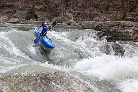 Jessica in a kayak in whitewater.